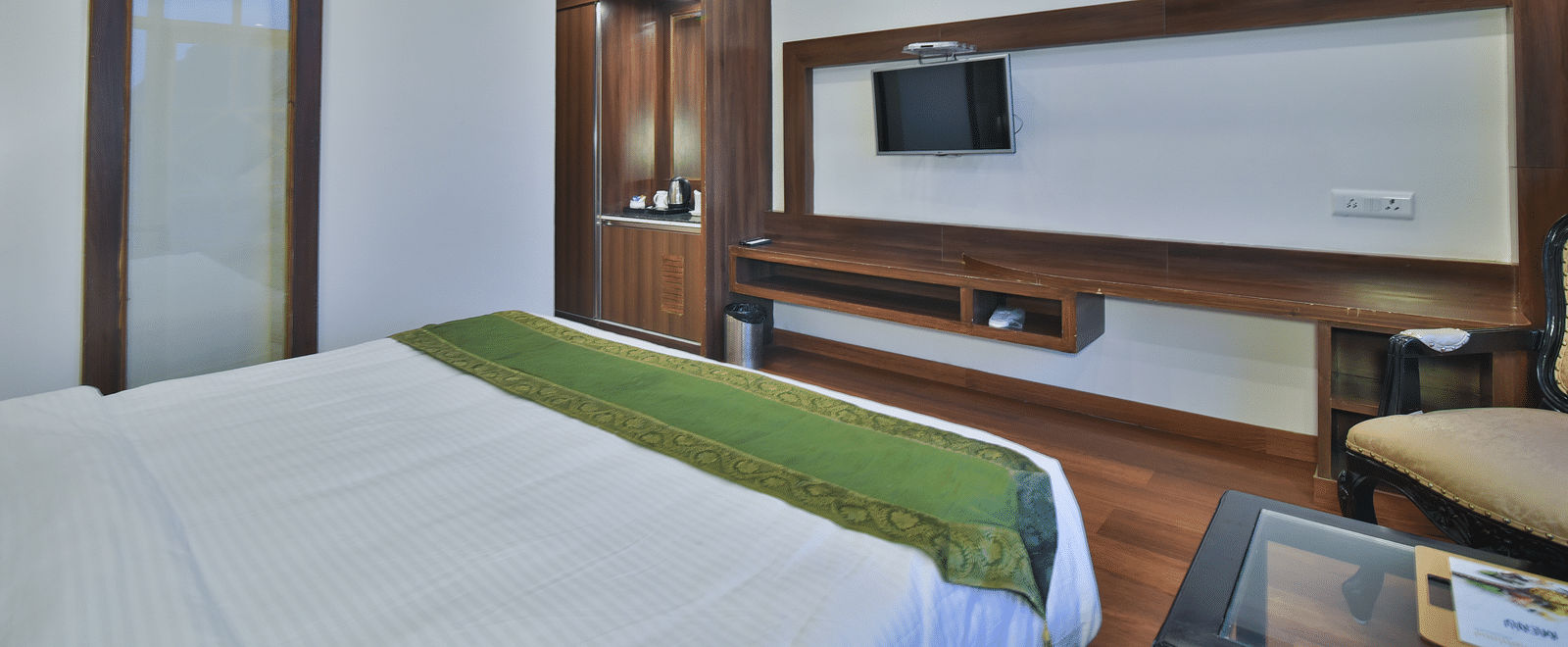 A view of the bed in front of the TV in the Premium Room at DLS Highland Resort and Spa, Mussoorie.